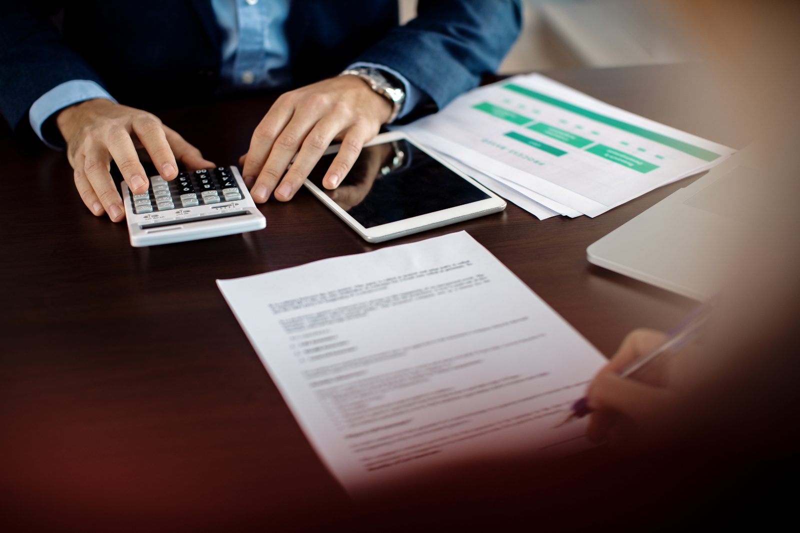 Dos personas revisando un presupuesto y firmando un acuerdo en una oficina